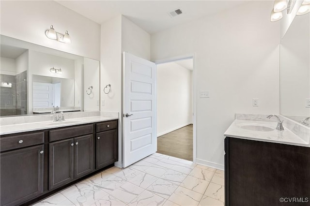 bathroom featuring visible vents, marble finish floor, a stall shower, and a sink