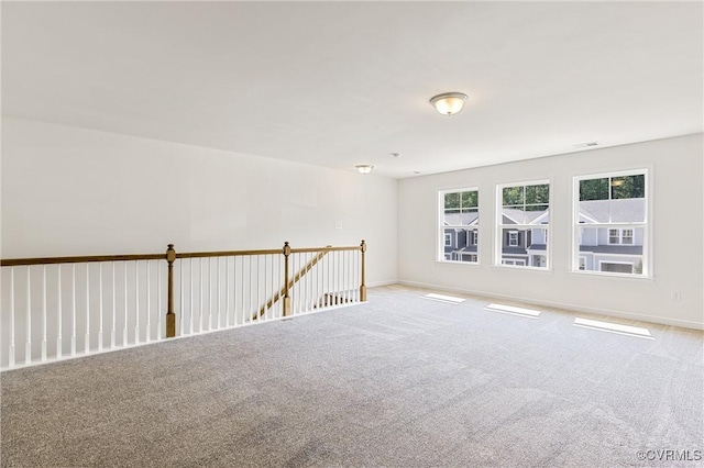 unfurnished room with carpet flooring, baseboards, and visible vents