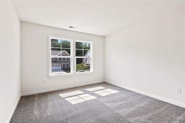 carpeted spare room featuring visible vents and baseboards