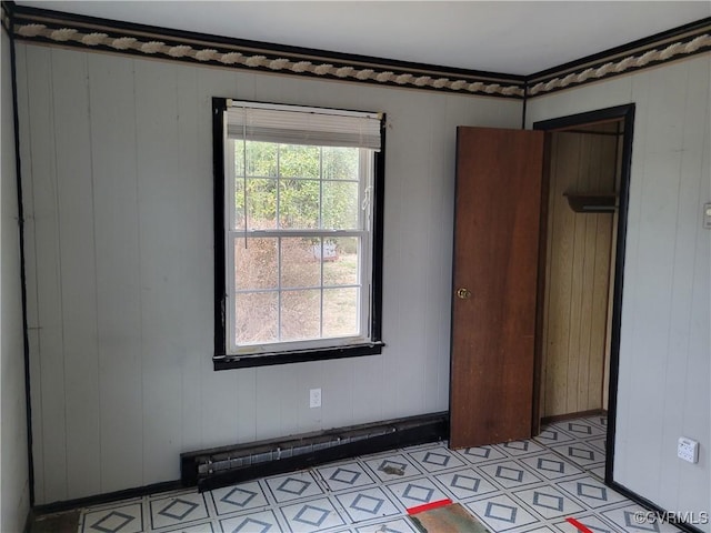 empty room with a wealth of natural light, light floors, and baseboards