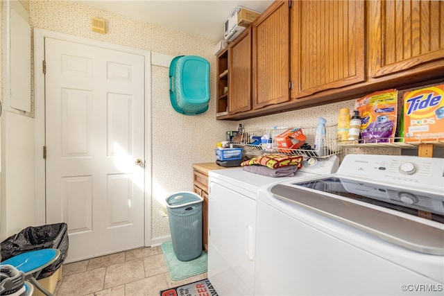 laundry room featuring cabinet space, light tile patterned floors, washing machine and dryer, and wallpapered walls