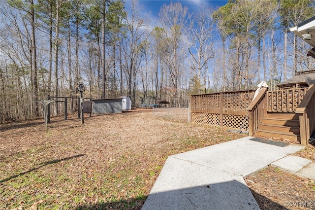 view of yard featuring a storage shed, an outdoor structure, and a wooden deck