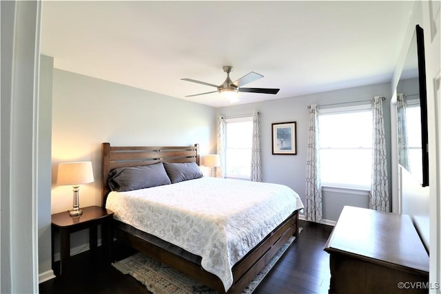 bedroom with a ceiling fan, dark wood-style floors, and baseboards