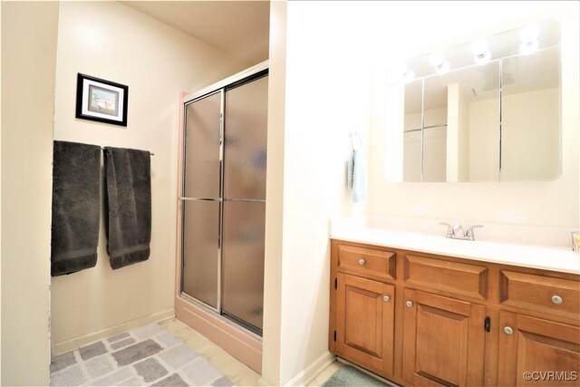 full bathroom featuring baseboards, vanity, and a shower stall