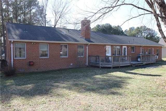 back of property with a lawn, a wooden deck, crawl space, brick siding, and a chimney