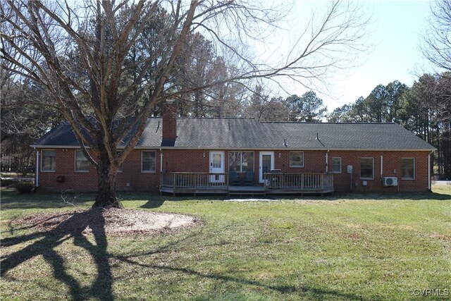 back of house featuring a deck, a lawn, brick siding, and a chimney