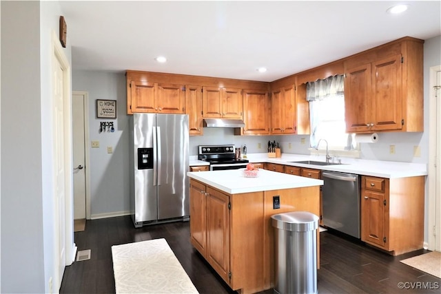 kitchen featuring a sink, stainless steel appliances, under cabinet range hood, and light countertops