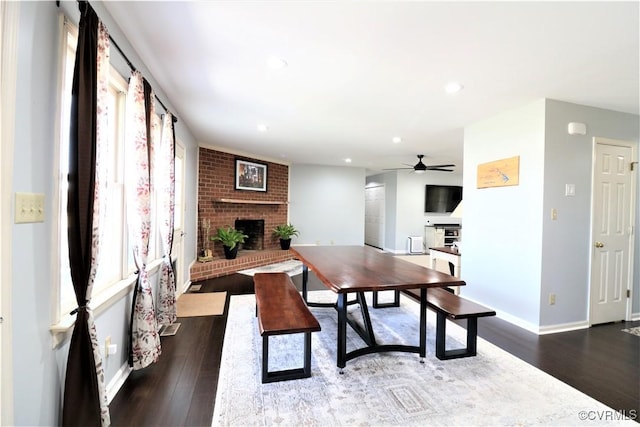 dining room featuring dark wood-style floors, recessed lighting, a fireplace, and baseboards