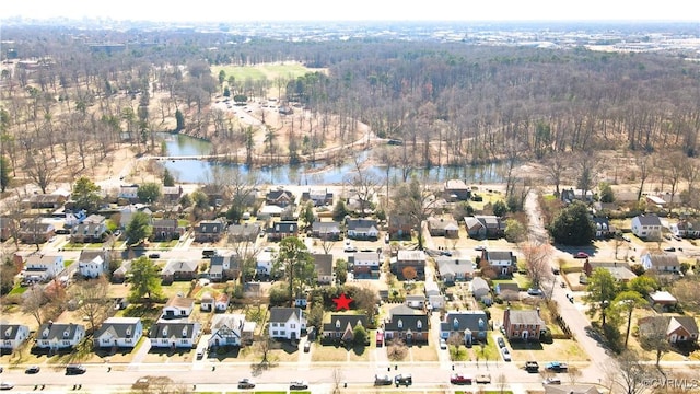 drone / aerial view with a residential view, a forest view, and a water view