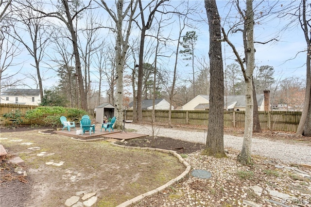 view of yard featuring a fenced backyard, a storage unit, and an outdoor structure