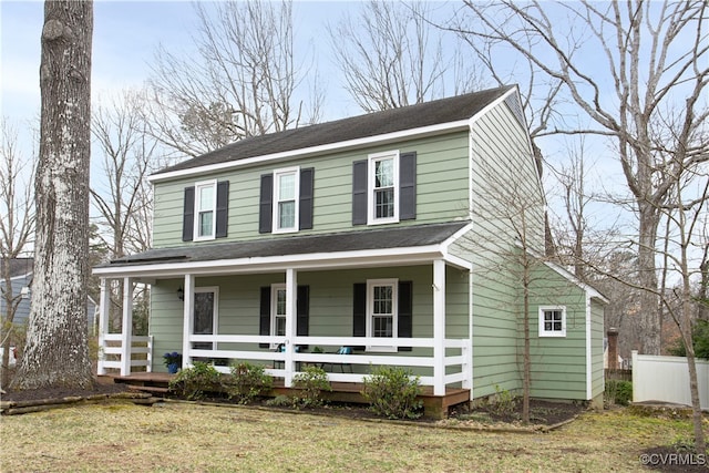 view of front of house with a porch, a front yard, and fence