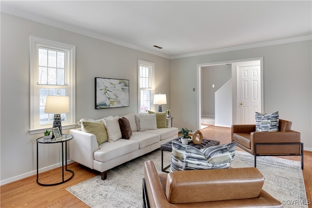 living room featuring light wood-style flooring, plenty of natural light, baseboards, and ornamental molding