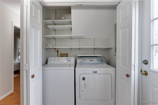 clothes washing area featuring washer and clothes dryer, laundry area, and light wood-type flooring