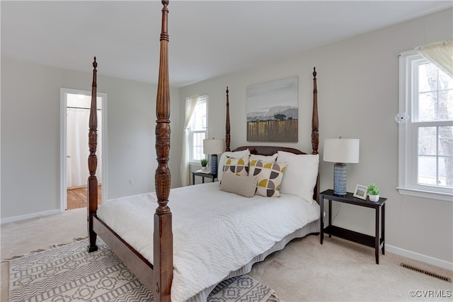 bedroom with multiple windows, light colored carpet, and visible vents