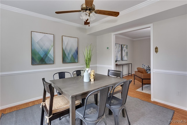 dining area with a ceiling fan, crown molding, and wood finished floors