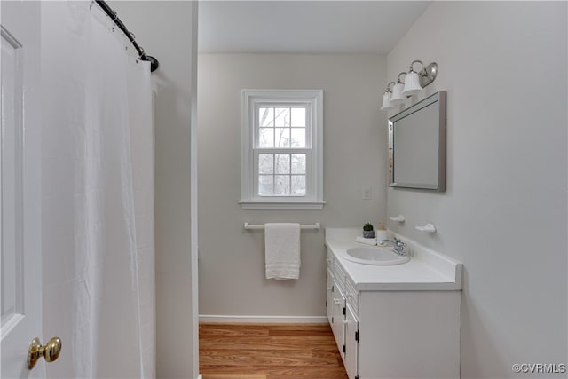 bathroom with a shower with curtain, vanity, baseboards, and wood finished floors