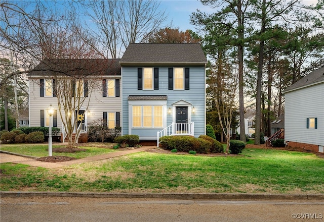 view of front of home with a front lawn and roof with shingles