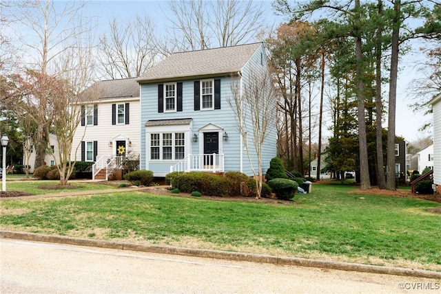 view of front of house featuring a front lawn and roof with shingles