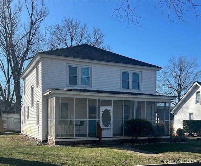 view of front of property with a front lawn, a sunroom, and roof with shingles