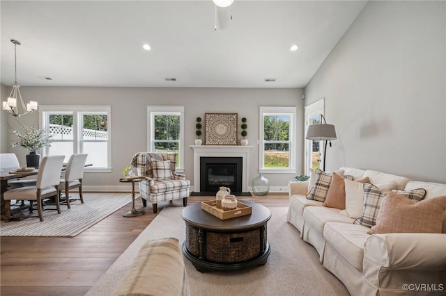 living room featuring recessed lighting, a chandelier, baseboards, and wood finished floors