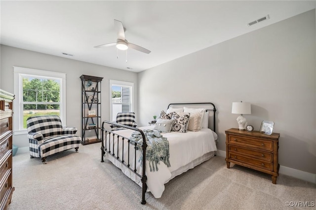 bedroom featuring light carpet, visible vents, ceiling fan, and baseboards