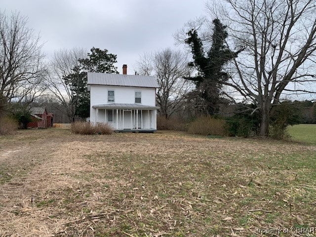 exterior space with a chimney and metal roof