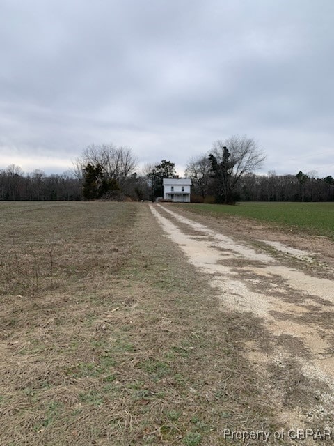 view of road featuring a rural view and dirt driveway