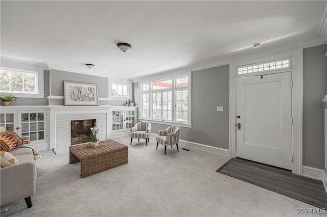 interior space featuring baseboards, a fireplace, ornamental molding, and carpet flooring