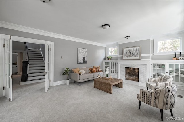 carpeted living area featuring stairway, baseboards, a fireplace, and crown molding