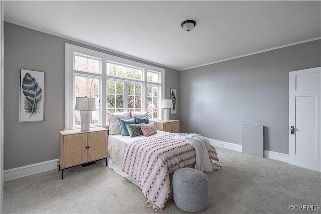 carpeted bedroom featuring crown molding and baseboards