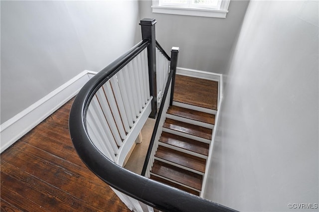 stairs with wood finished floors and baseboards