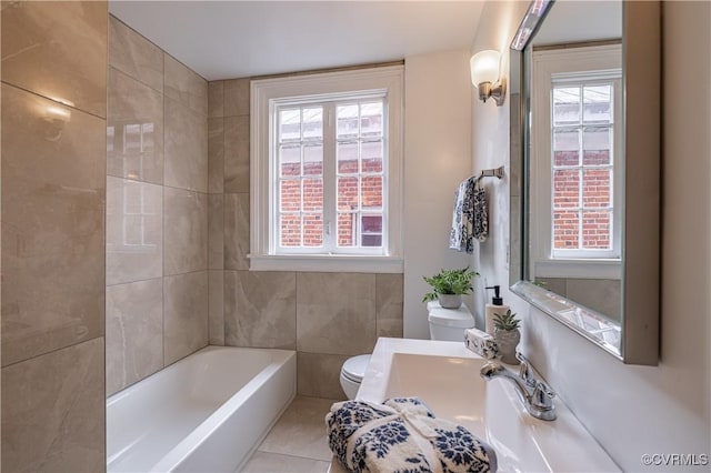 bathroom with toilet, tile patterned floors, plenty of natural light, and a washtub