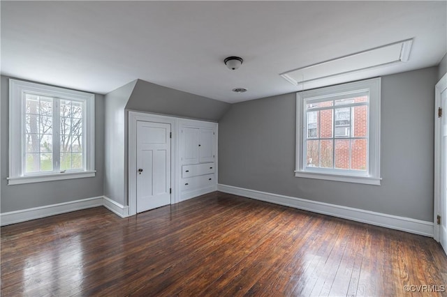 additional living space featuring vaulted ceiling, visible vents, baseboards, and wood-type flooring