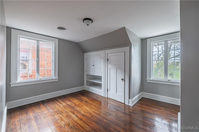 bonus room with visible vents, baseboards, lofted ceiling, and dark wood finished floors