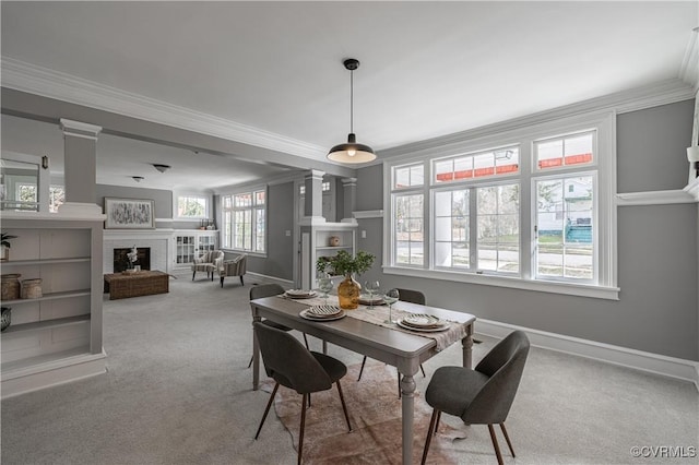 dining room featuring ornamental molding, a fireplace, baseboards, and carpet floors