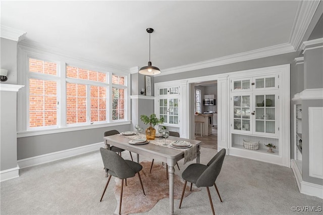 carpeted dining room with baseboards and ornamental molding