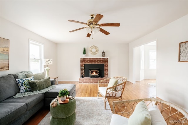 living room featuring baseboards, plenty of natural light, wood finished floors, and a ceiling fan