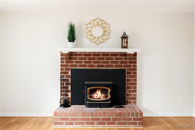 interior details featuring a brick fireplace, baseboards, and wood finished floors