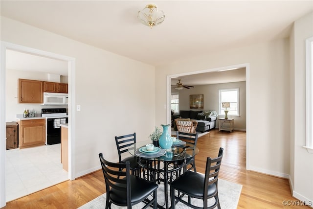 dining space with light wood finished floors and baseboards