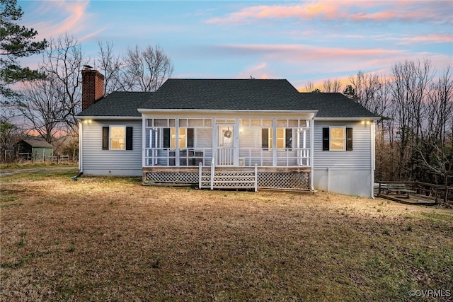 back of house featuring a lawn, a porch, a shingled roof, crawl space, and a chimney