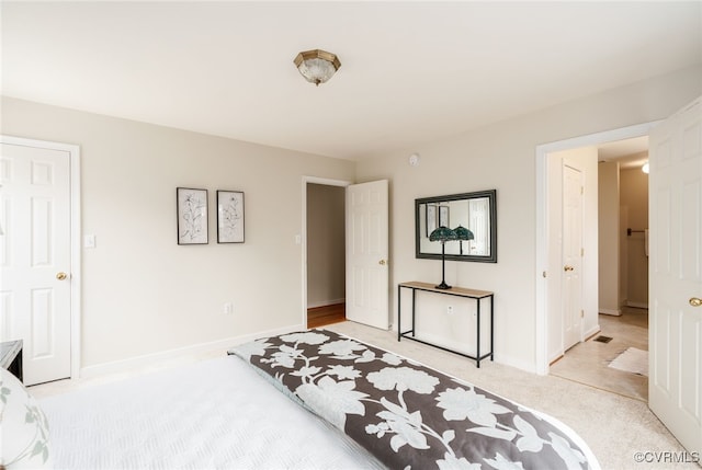 bedroom featuring light carpet and baseboards