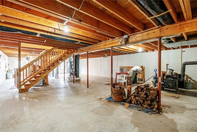 basement with stairs and a wood stove