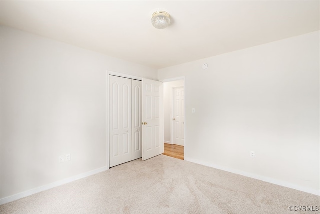 unfurnished bedroom with a closet, baseboards, and carpet flooring