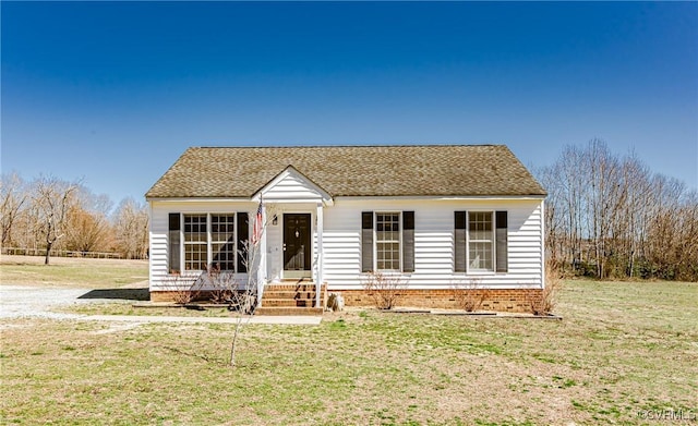 view of front of house with a front lawn and a shingled roof