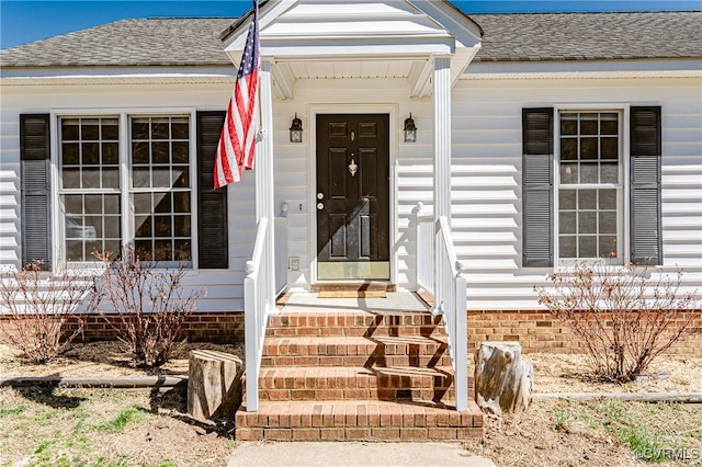 property entrance with a shingled roof