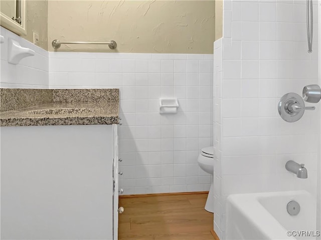 bathroom featuring tile walls, vanity, and wood finished floors