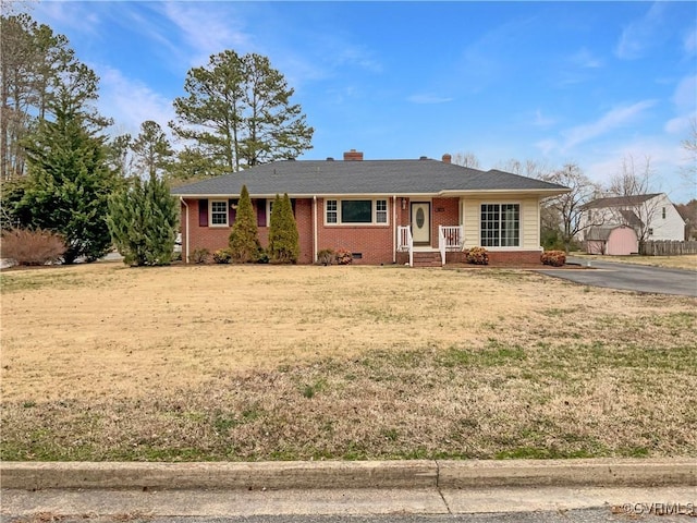 ranch-style house with a front yard, a chimney, brick siding, and crawl space