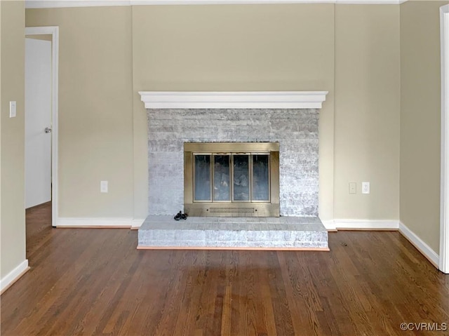 details featuring a stone fireplace, wood finished floors, and baseboards