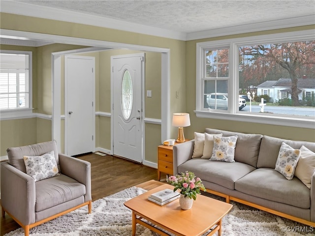 living area with a textured ceiling, baseboards, and wood finished floors