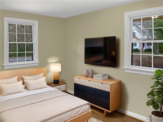 bedroom featuring baseboards and wood finished floors